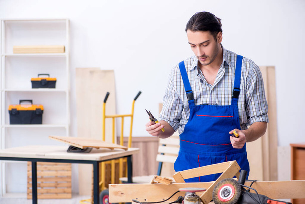 Joven carpintero masculino trabajando en interiores - Foto, Imagen
