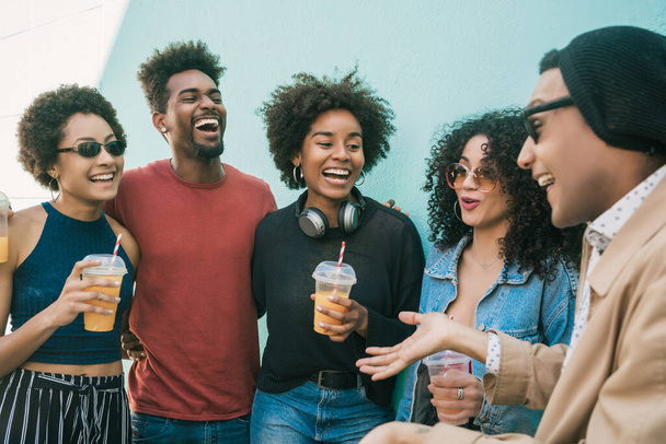 Portrait of multi-ethnic group of friends having fun together and enjoying good time while drinking fresh fruit juice.  - Foto, Imagem