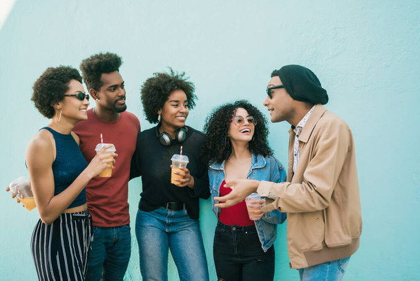 Portrait of multi-ethnic group of friends having fun together and enjoying good time while drinking fresh fruit juice.  - Foto, afbeelding