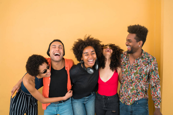 Portrait of Afro friends having fun together and enjoying good time against yellow background. Friendship and lifestyle concept. - Photo, image