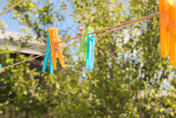Coloured plastic pegs on the clothes line in Australian summer - Photo, Image