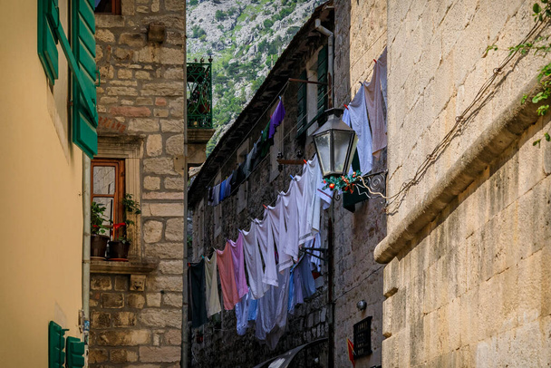 Pittoreske smalle straatjes van de goed bewaarde middeleeuwse oude stad met wasgoed buiten in Kotor, Montenegro in de Balkan - Foto, afbeelding
