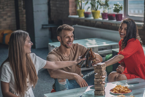 Smiling friends drinking beer and playing board games - Fotoğraf, Görsel