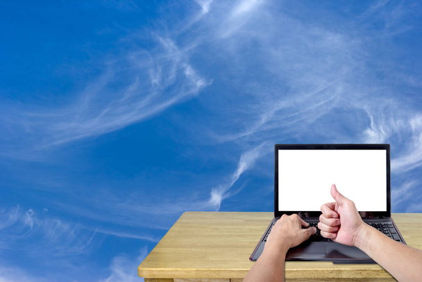 pouces levés avec écran d'ordinateur portable vide sur le bureau et le fond du ciel - Photo, image