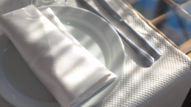 fehér tányér szalvéta evőeszközökkel az asztalterítőn - Felvétel, videó