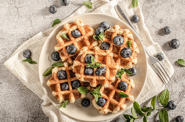 Delicious sweet breakfast, cripsy waffles, fresh berries and maple syrup - Фото, изображение
