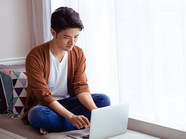 Young man wearing casual clothes and using laptop - Foto, Bild