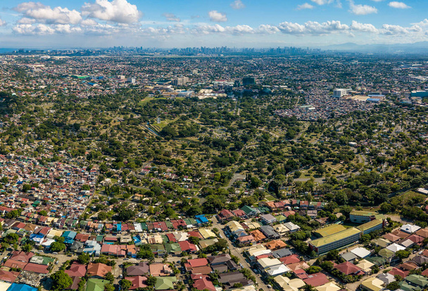 Luftaufnahme vom Manila Memorial Park in Sucat, Paranaque, Metro Manila, Philippinen. Der große Friedhof wird flankiert von Slumgebieten und einer Unterteilung. - Foto, Bild