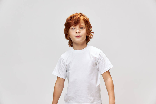 Redhead teenager in white t-shirt cropped view gray background studio  - Photo, image
