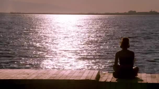  Mujer solitaria escuchando música en la playa, mirando al horizonte - Imágenes, Vídeo