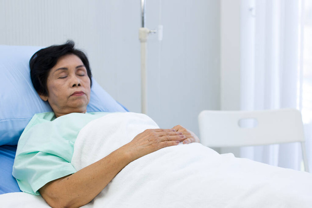 Az idős nő a kórházi ágyon alszik.. - Fotó, kép