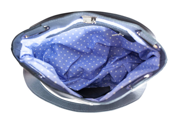 Draufsicht auf leere handgefertigte weiche Lederhandtasche mit blau gepunktetem Innenfutter isoliert auf weißem Hintergrund - Foto, Bild