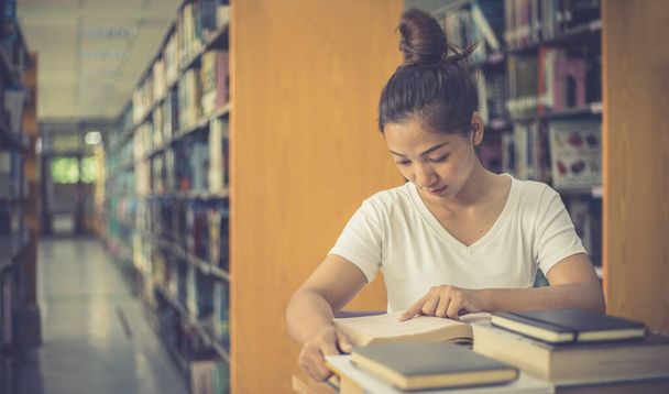 Asiáticas estudiantes universitarias están leyendo y estudiando en la biblioteca, Aprendiendo en la biblioteca Concepto - Foto, imagen