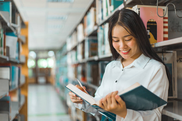 Des étudiantes asiatiques lisent et étudient à la bibliothèque, Apprendre à la bibliothèque Concept - Photo, image