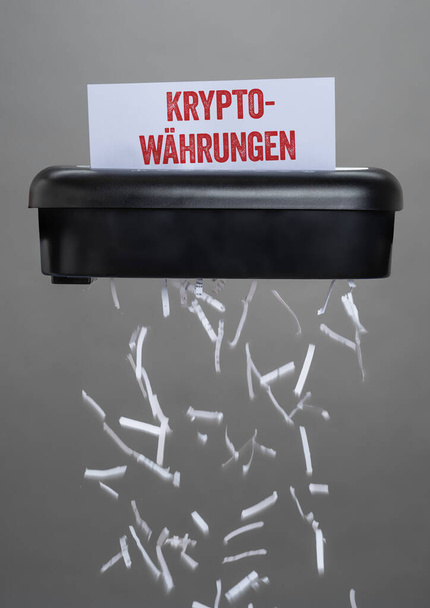 Una trituradora destruyendo un documento - Criptomonedas - Kryptowaehrungen alemán - Foto, imagen