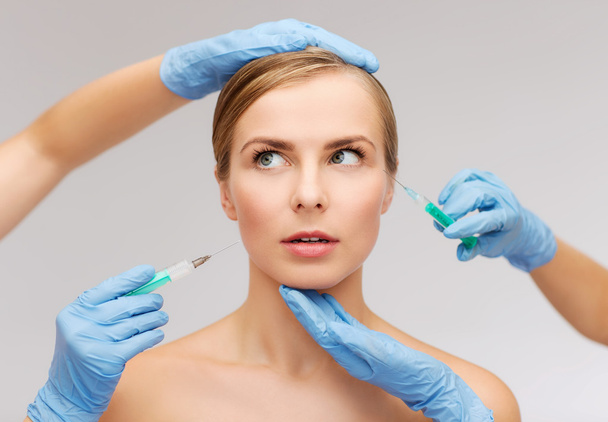 Woman face and beautician hands with syringe - Foto, afbeelding