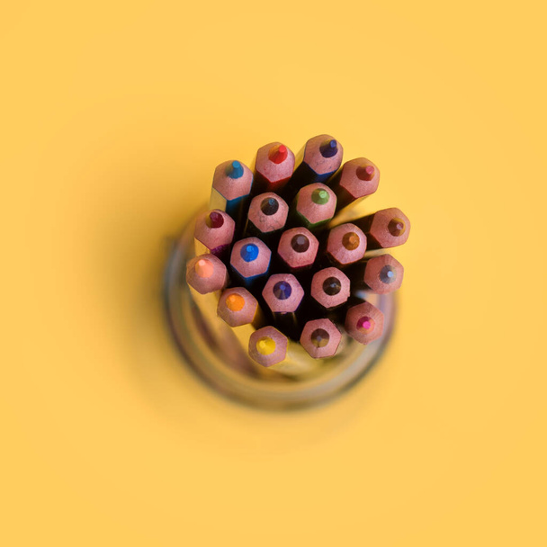 Lápices de colores en un frasco sobre un fondo amarillo - Foto, imagen