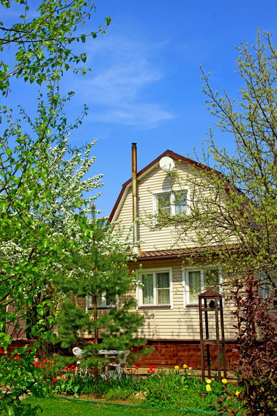 Садовий будинок в оточенні квітучих дерев
 - Фото, зображення