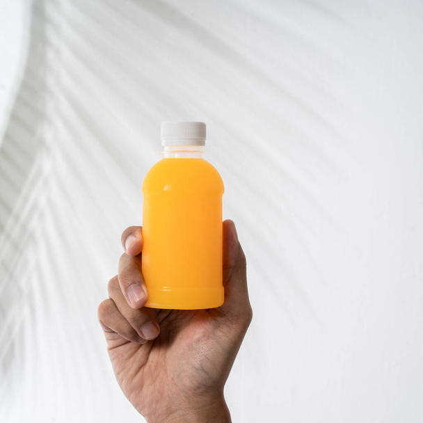 hand holding beverage product on plastic bottle mockup - Foto, Imagem
