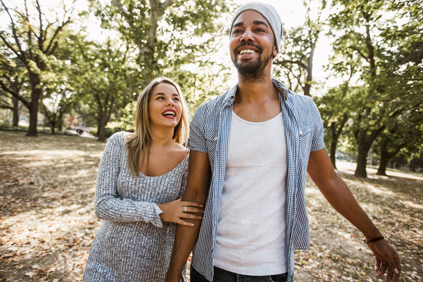 Retrato al aire libre de pareja joven de raza mixta romántica y feliz en parque - Foto, Imagen