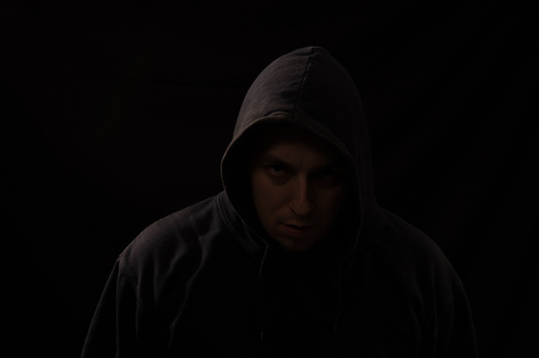 Porträt eines Mannes im Dunkeln, der dich mit einer Sca direkt ansieht - Foto, Bild