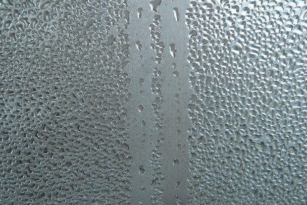Яскраво-сіра кольорова скляна текстура, з краплями води на ній. Вода падає скляний фон
 - Фото, зображення