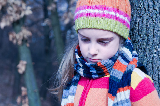 Sad little girl in the autumn park - Foto, imagen