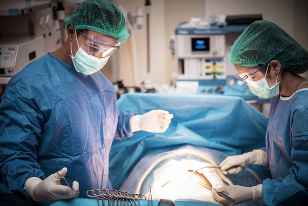 Ομάδα ιατρών ή χειρουργών στην νοσοκομειακή χειρουργική που χειρίζονται επείγοντα περιστατικά και παρουσιάζουν καρδιακό ρυθμό ασθενούς, κατά τη διάρκεια της κρίσης του κορωναϊού ή του ιού covid-19, ιατρική έννοια.  - Φωτογραφία, εικόνα