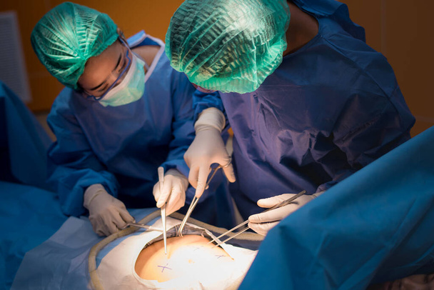 Команда врачей или хирургов в стационарной хирургии операционная неотложной помощи показывает сердечный ритм пациента, во время коронавируса или ковид-19 кризиса, медицинская концепция..  - Фото, изображение