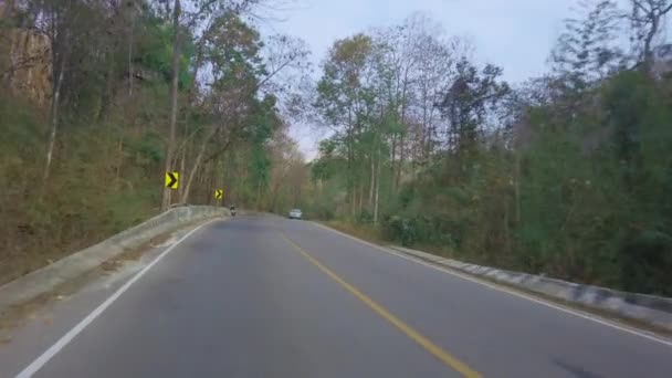 Auf einer Bergstraße im thailändischen Nationalpark. Sichtweise Autofahren. Blick aus dem Inneren des Autos, Motorrad POV Fahraufnahmen 4K - Filmmaterial, Video