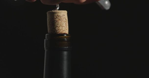 Korkenzieher öffnet eine Flasche Rotwein - Foto, Bild