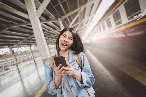 Glücklich lächelnde asiatische Touristin mit Backpacker am Bahnsteig - Foto, Bild