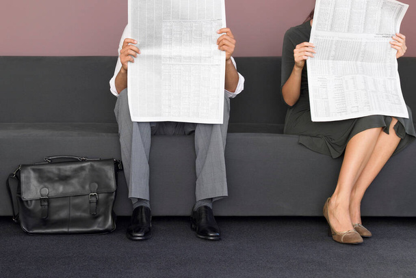 Cropped image of man and woman reading newspaper - Photo, image