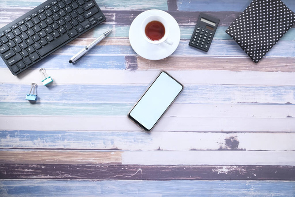 смартфон с пустым экраном и офисными принадлежностями на столе  - Фото, изображение
