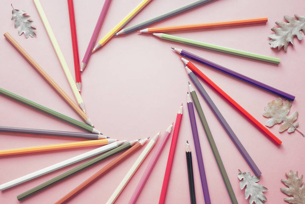 Pastellfarbige Bleistifte und trockene Eichenblätter, Papierhintergrund. Runde Freiräume für Text - Foto, Bild