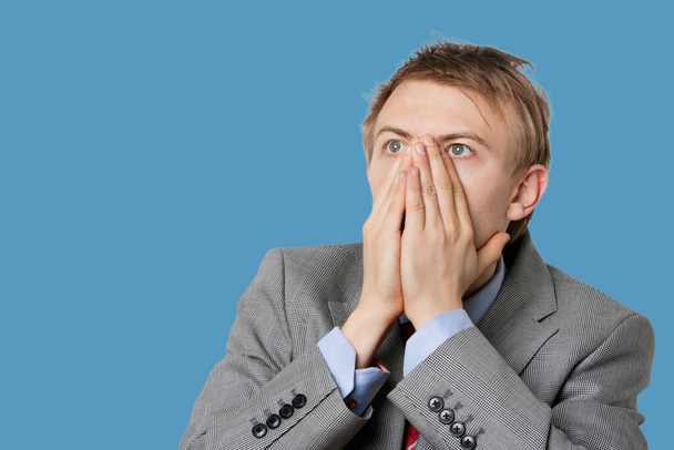 Close-up of a shocked businessman with hands covering mouth - Foto, immagini