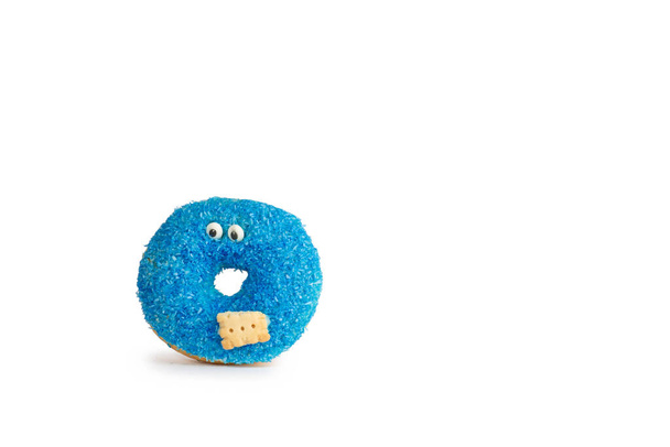 Blauwe donut met ogen en biscuit geïsoleerd op blauwe achtergrond met zachte schaduw - Foto, afbeelding