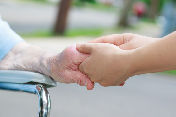 Caregiver holding elderly womans hand - Foto, afbeelding