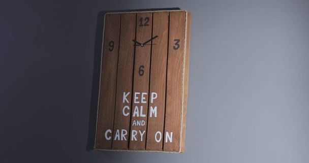 A wooden handmade clock on the wall with a writing, inscription, record - Keep calm and carry on - Valokuva, kuva