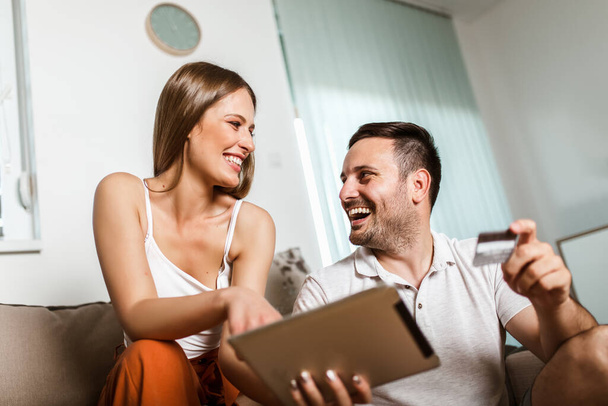 Mutlu genç çift tabletle online alışveriş yapıyor. - Fotoğraf, Görsel