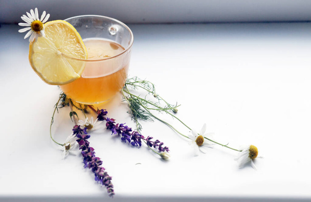 a cup of honey with a lemon slice and field flowers - Zdjęcie, obraz