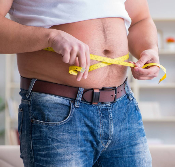 Hombre que sufre de peso extra en concepto de dieta - Foto, imagen