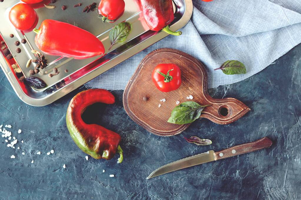 Rode groente tomaten en paprika 's, specerijen op tafel, bovenaanzicht, gezond seizoensgebonden voedselconcept, thuiskoken - Foto, afbeelding