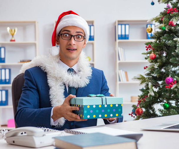 Üzletember ünnepli karácsony ünnepe az irodában - Fotó, kép