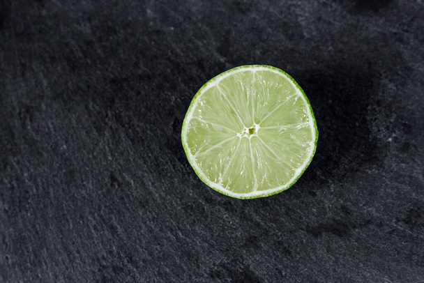 Lime background. The slices of lime on a stone base. On a stone table. Free space for text . The view from the top - Fotografie, Obrázek