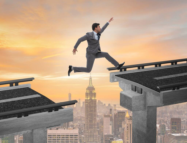 Молодий бізнесмен стрибає через міст
 - Фото, зображення