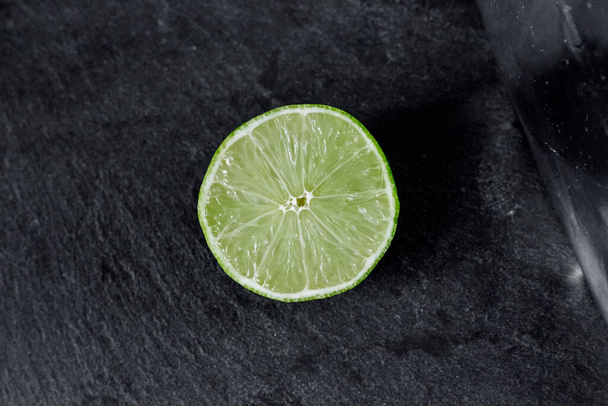 Lime background. The slices of lime on a stone base. On a stone table. Free space for text . The view from the top - Photo, image