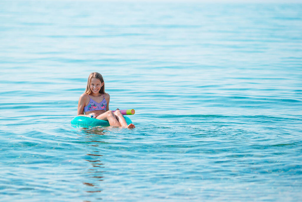 Adorable girl on inflatable air mattress in the sea - Foto, immagini