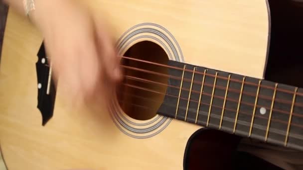 Το χέρι του κοριτσιού παίζει strum σε ακουστική κιθάρα. Κοντινό πλάνο, επιλεκτική λήψη. - Πλάνα, βίντεο