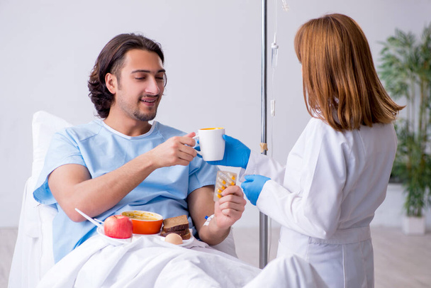 Paciente masculino comiendo alimentos en el hospital
 - Foto, imagen